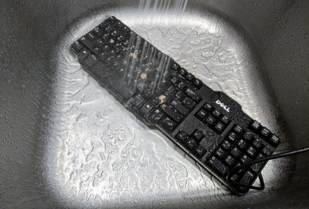 I Spilled Cereal on My Keyboard and You Won't Believe What Happened Next 5 Washing a keyboard in a kitchen sink.