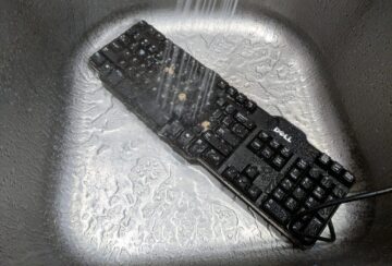 Washing a keyboard in a kitchen sink.